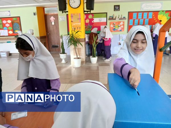 انگشت‌های رنگین دختران دبستان اندیشه روی برگه‌های رأی انتخابات شورای دانش‌آموزی